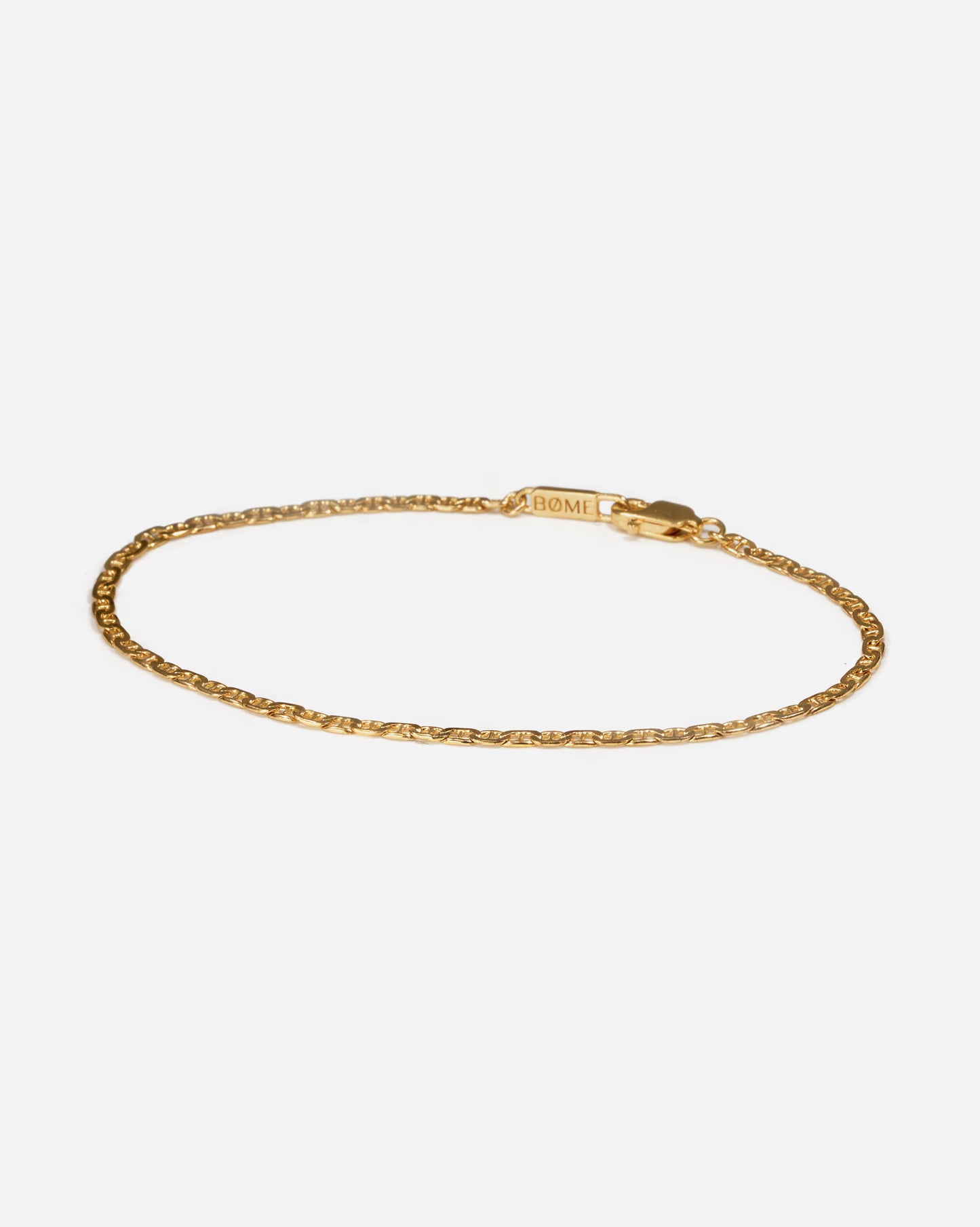 Gold flat mariner chain bracelet for men by BØME, showcasing a sleek, contemporary design with flat, interlocking links that offer both durability and elegance. The polished gold finish adds a bold, masculine touch, making it a versatile accessory for any occasion.